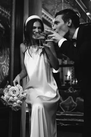 Wedding photo: couple toasting champagne black white
