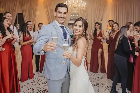 Wedding photo: couple toasting champagne red bridesmaids