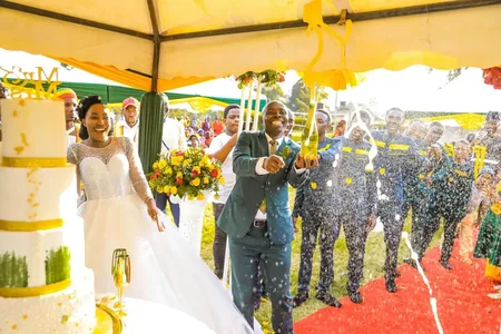 Wedding photo: groom popping champagne outdoor cake