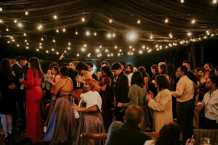Wedding photo: guests dancing string lights reception